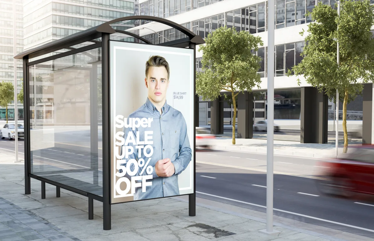 Affiche publicitaire 120 × 176 cm dans un abribus vitré en bord de rue