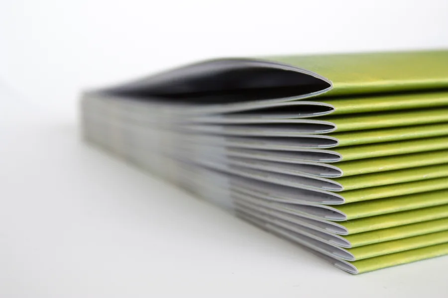 Pile de brochures agrafées vue de tranche montrant leur épaisseur