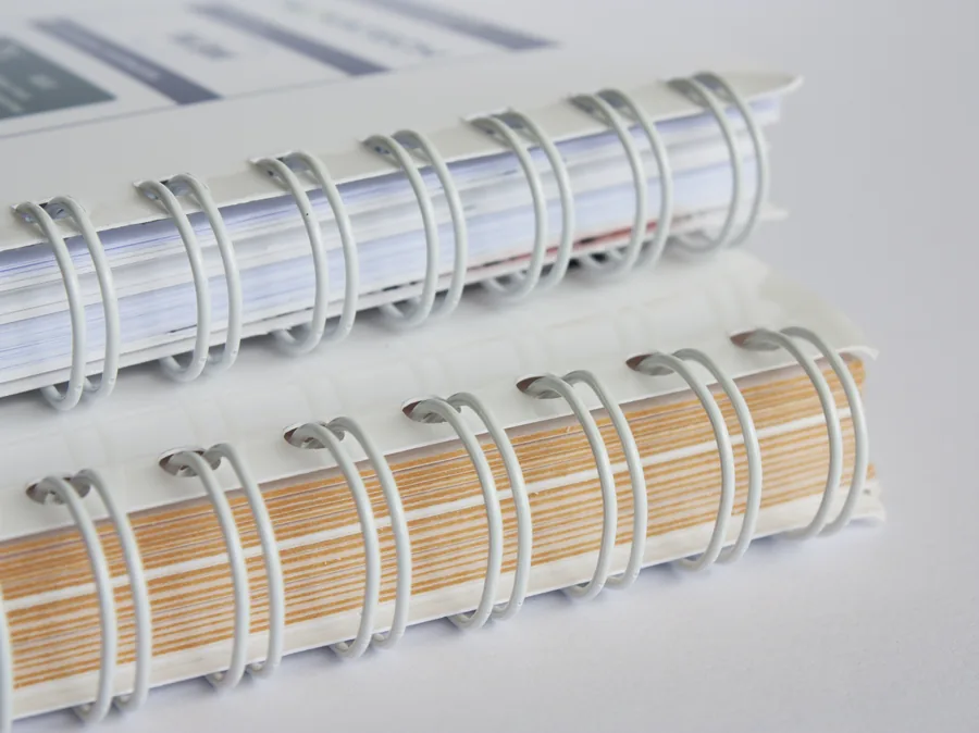 Deux documents reliés en Wire-O blanc, vue rapprochée des doubles anneaux métalliques