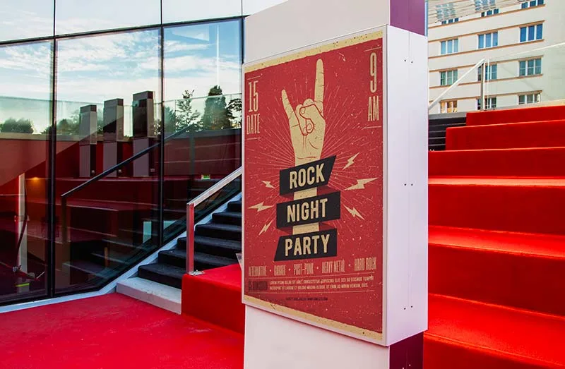 Porte-affiche extérieur sur pied devant un bâtiment, avec une affiche événementielle